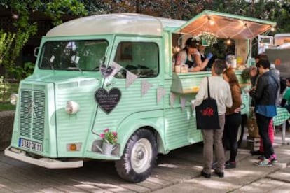 Unos clientes compran comida en un food truck.