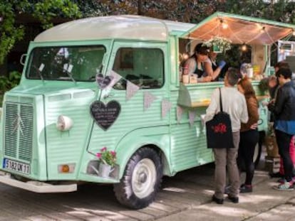 Unos clientes compran comida en un food truck.