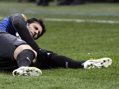 Diego Milito se duele de la rodilla en el suelo durante el partido ante el Cluj