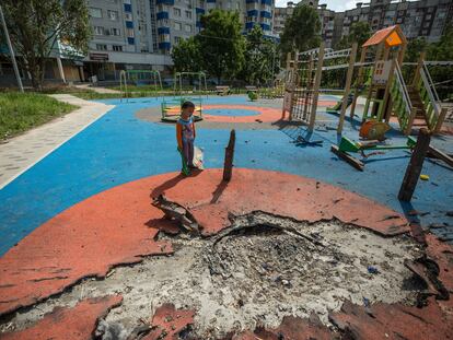 Un niño ucranio de 4 años juega en un parque infantil parcialmente destruido por los bombardeos rusos en Járkov, Ucrania.