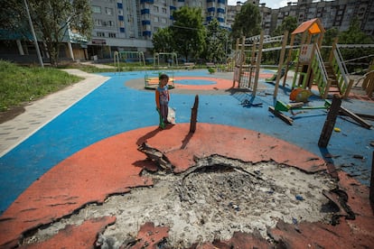 Un niño ucranio de 4 años juega en un parque infantil parcialmente destruido por los bombardeos rusos en Járkov, Ucrania.