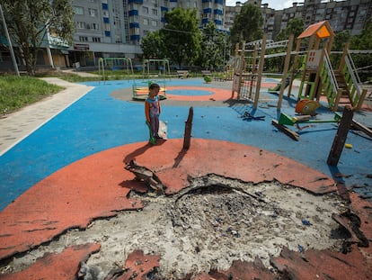 Un niño ucranio de 4 años juega en un parque infantil parcialmente destruido por los bombardeos rusos en Járkov, Ucrania.