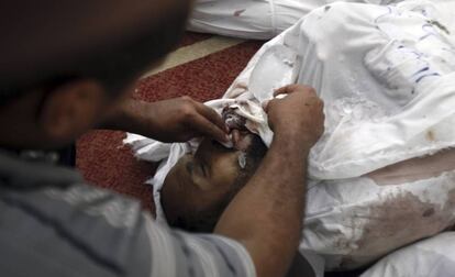 Un hombre coloca hielo en los labios del cuerpo de su hermano, miembro de los hermanos musulmanes que ha fallecido durante los enfrentamientos con las fuerzas de seguridad egipcias. Mezquita de El Eyman, El Cairo.