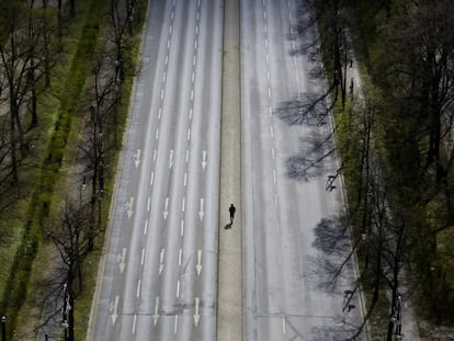 Un hombre camina por el bulevar vacío Hofjaegerallee de Berlín (Alemania).