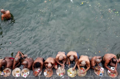 Devotos hindúes rezan tras un baño sagrado en honor a las almas de sus difuntos ancestros en el día de Mahalaya, también llamado Shraadh o Pitru Paksha, en Bombai (India).