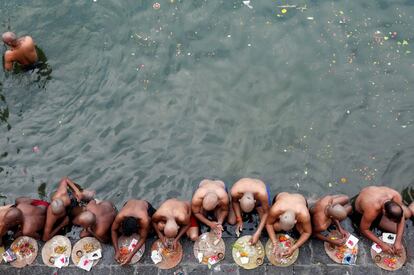 Devotos hindúes rezan tras un baño sagrado en honor a las almas de sus difuntos ancestros en el día de Mahalaya, también llamado Shraadh o Pitru Paksha, en Bombai (India).