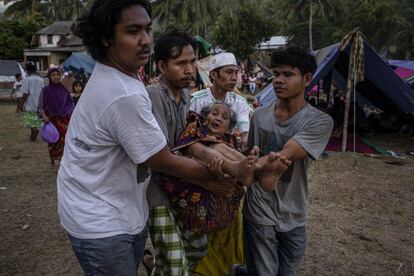 Indonesios llevan a una mujer mayor en un refugio temporal, en Pemenang.