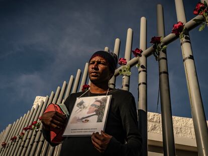 Un hombre de origen venezolano sostiene la fotografía de un amigo suyo que perdió la vida durante el incendio del Instituto Nacional de Migración del pasado lunes, en Ciudad Juárez (México).