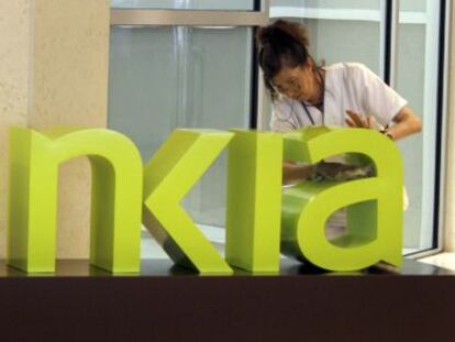 Una operaria limpia el logo de Bankia. EFE/Archivo