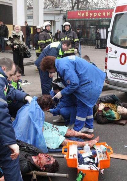 Personal sanitario y policías se ocupan de los heridos ante la estación de metro de Park Kultury.