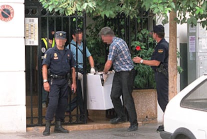 Agentes de policía trasladan objetos hallados en el piso utilizado por ETA en Valencia.