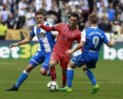 Juanmi conduce el bal&oacute;n entre Sch&auml;r (I) y Fede Cartabia en el partido contra el Deportivo. 