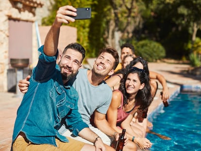 Un grupo de jóvenes toman un selfi en la piscina.