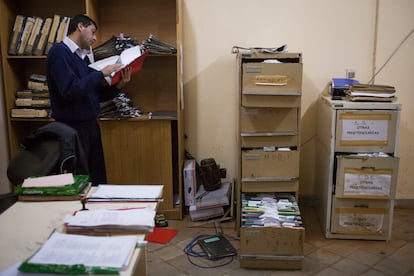 Un funcionario trabaja en una oficina rebasada de expedientes carcelarios.