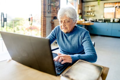 Mujer mayor trabaja en su computadora