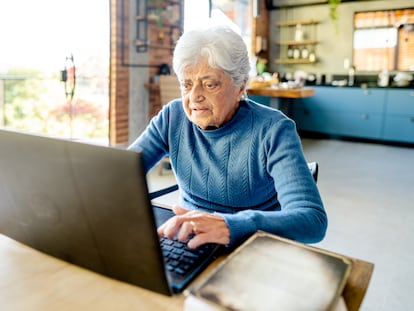 Una mujer mayor trabaja en su computadora en una fotografía ilustrativa.