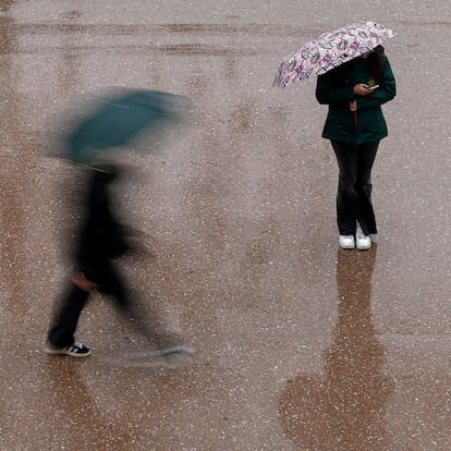 GRAFCVA6016. VALENCIA, 05/03/2025.- Dos personas se protegen con paraguas de la lluvia que puede acumular 100 litros por metro cuadrado en doce horas en las provincias de Valencia y Castellón durante este miércoles y mañana jueves, y en todo el episodio de precipitaciones que lleva activo desde el lunes se pueden alcanzar o superar los 400 litros acumulados, especialmente en el interior y prelitoral según la Agencia Estatal de Meteorología (Aemet). EFE/Biel Aliño