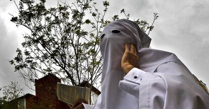 Un penitente de la Hermandad de La Paz espera a saber si saldr&aacute; su cofrad&iacute;a en estaci&oacute;n de penitencia, en Sevilla.