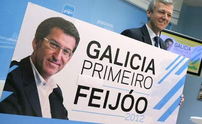 El secretario general del PPdG y responsable de la campaña electoral, Alfonso Rueda, sostiene el cartel con la imagen del presidente de la Xunta