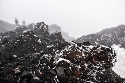 La neblina engulle a dos montañeros que descienden de la cumbre del Tungurahua. Este volcán de 5.023 metros de altura contaba hace varias décadas con su propio glaciar. No obstante, las erupciones que se han sucedido desde 1999 han acabado por derretir el hielo, que ya solo se encuentra en pequeñas cantidades en las inmediaciones de su cráter.