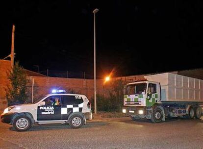 Un vehículo de la Policía Municiapl acompaña a varios camiones de basura a su paso por la Cañada Real Galiana.