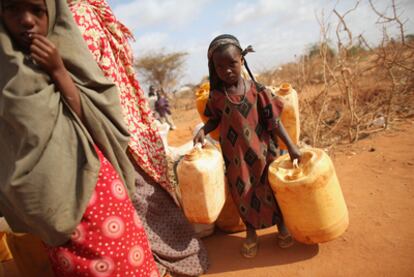 Una niña somalí carga con garrafas de agua en las afueras del campamento de refugiados de Dadaab, en Kenia.