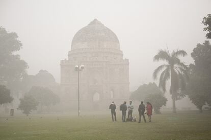 Un grupo de personas pasa el día en un parque cubierto de polvo y smog, en Mumbai (India).