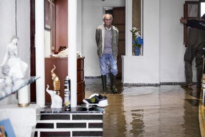 Un hombre mira consternado el interior de su casa inundada, en Valencia.