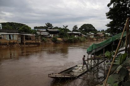 Un hombre carga su bote con sacos en el río Moei, frontera natural entre Tailandia y Myanmar. Esta es una de las principales vías de llegada de los refugiados. 