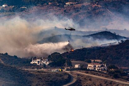 Un helicóptero participa en las labores de extinción del incendio en Mijas (Málaga), este domingo.