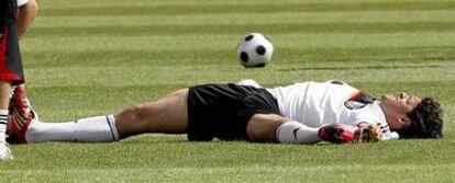 Ballack realiza estiramientos durante el entrenamiento de ayer de Alemania.