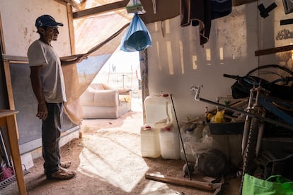 Alberto Jiménez muestra botellas donde almacena agua en una invasión de casas en Cabo San Lucas.