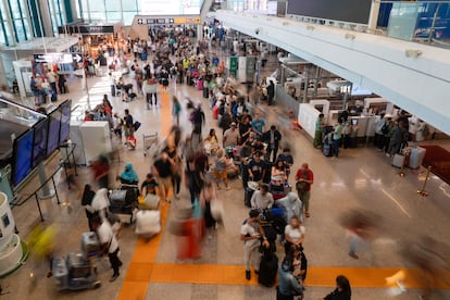 Centenares de pasajeros esperan en la terminal internacional en el aeropuerto de Roma-Fiumicino, este viernes. 