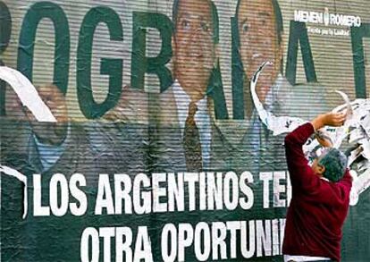 Un argentino arranca un cartel de propaganda del candidato a la presidencia Carlos Menem, en Buenos Aires.