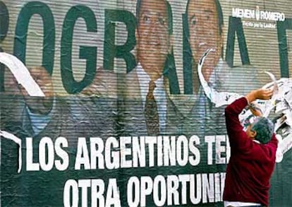 Un argentino arranca un cartel de propaganda del candidato a la presidencia Carlos Menem, en Buenos Aires.