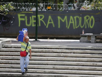 Un hombre pasa junto a una pintada contra Nicolás Maduro en Caracas.