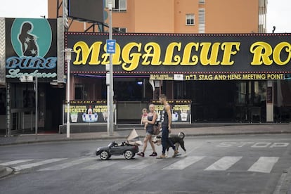 Una familia pasea por la mañana por la calle de bares de Magaluf.