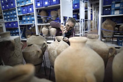 Una estudiante inspecciona unas vasijas en el Dep&oacute;sito de los Tesoros Nacionales.