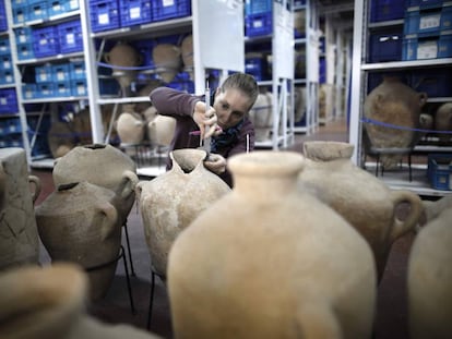 Una estudiante inspecciona unas vasijas en el Depósito de los Tesoros Nacionales.