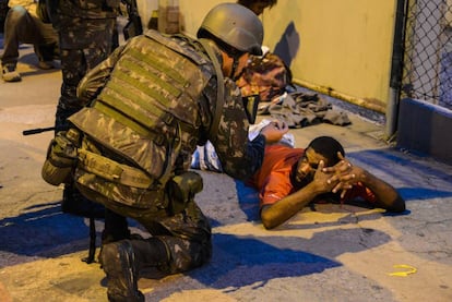 Soldados do exército revistam pessoas nesta segunda, em Vitória.