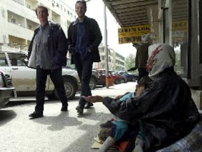 Una indigente gitana con su hijo en los brazos pide dinero a unos viandantes, ayer en Pogdorica.