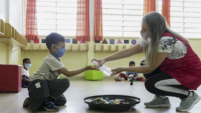 Los centros escolares de São Paulo volvieron a abrir cumpliendo con la decisión del alcalde de São Paulo, Bruno Covas, de retomar las clases presenciales. El Ayuntamiento autorizó que el 35% de los alumnos regresara a las aulas, mientras los demás deberían seguir con las actividades de manera virtual. En la imagen, una maestra dispensa gel desinfectante a uno de sus pequeños alumnos.