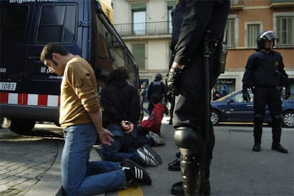 La policía mantiene arrodillados a los jóvenes detenidos durante los altercados.