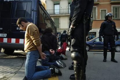 La policía mantiene arrodillados a los jóvenes detenidos durante los altercados.