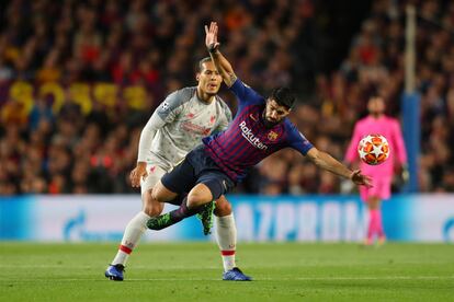 Virgil van Dijk pelea un balón con Luis Suárez. 