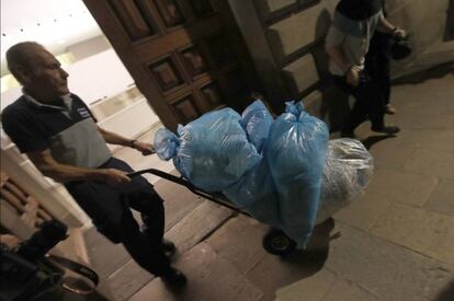 Un trabajador saca del Palau de la Generalitat varias bolsas con documentos triturados ayer por la noche.