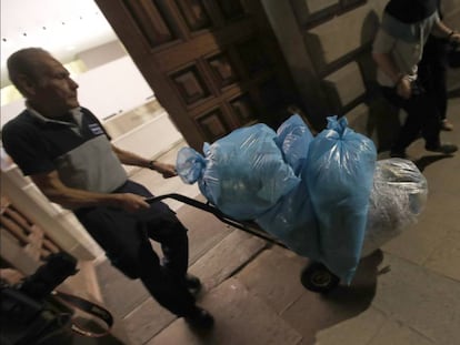 Un trabajador saca del Palau de la Generalitat varias bolsas con documentos triturados ayer por la noche.