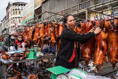 Una mujer vende cerdos asados en un mercado de Phnom Penh, (Camboya). Camboya se prepara para celebrar el Año Nuevo Lunar a medida que el gobierno tomó medidas graduales para reabrir las fronteras durante los meses anteriores, incluida la bienvenida al país a los turistas vacunados.