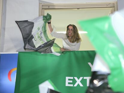 María Guardiola alza una bandera de Extremadura en la sede del PP en Mérida, durante la noche electoral.