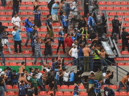 La violencia entre seguidores del Atleti mexicano y el Querétaro obligó a los espectadores a refugiarse en el césped